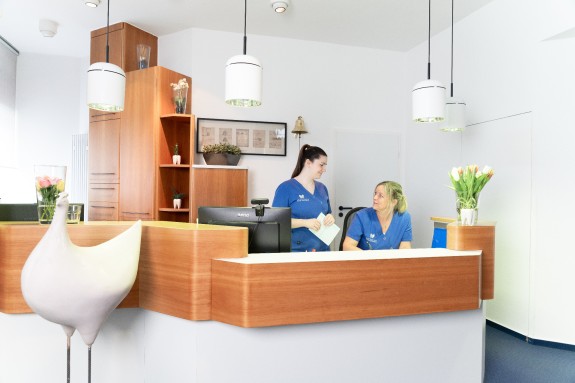 Zwei ZFAs besprechen sich am Empfang | Zahnarztpraxis Kamberci in Olpe